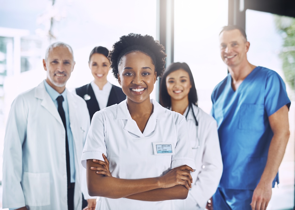 Smiling medical team standing in the entrance to a healthcare facility