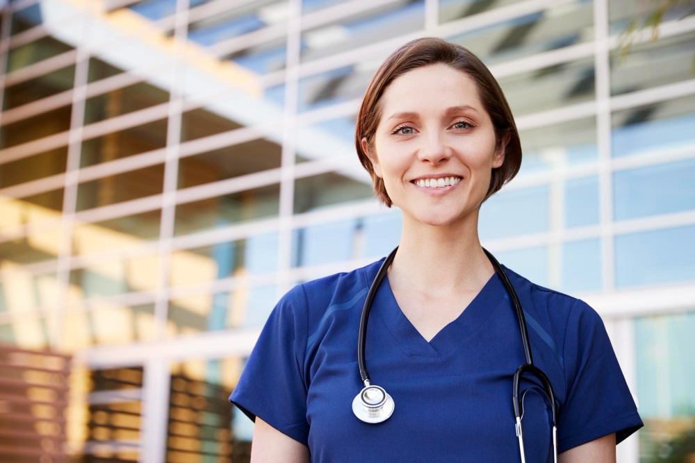 Smiling allied health technologist walking out of a medical facility.