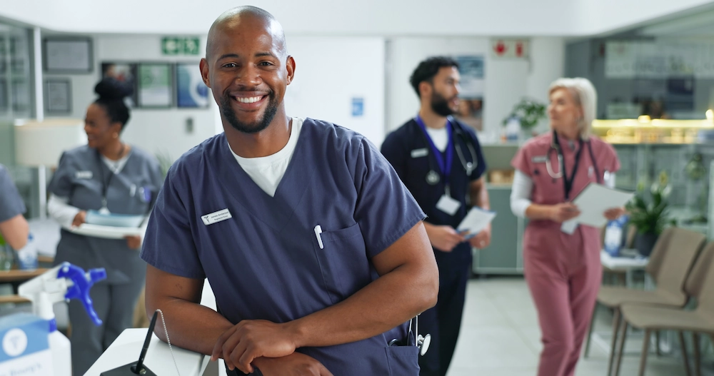 Smiling travel technologist in a hallway at a medical facility.