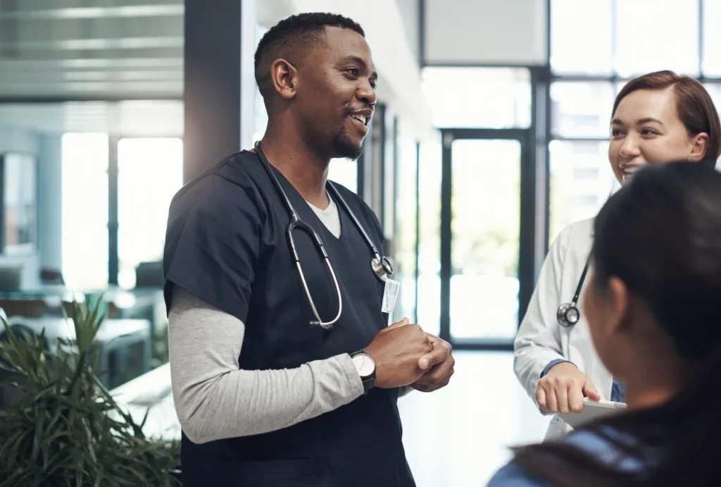 Healthcare travelers talking about their day in a hallway.
