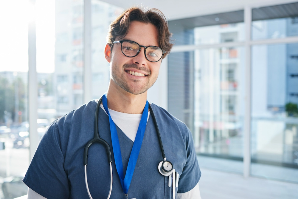 Smiling clinician in front of a healthcare facility.