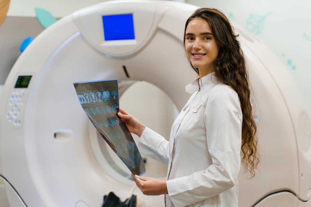 Smiling CT Technologist holding a results sheet.