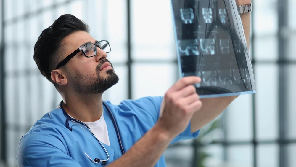 Travel radiology tech examining an X-ray.
