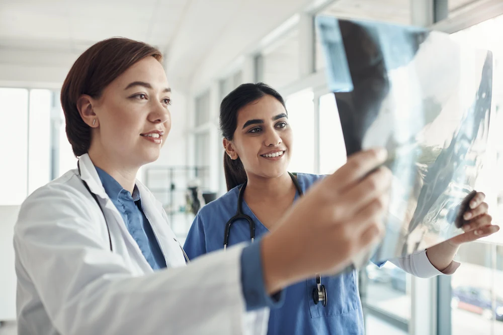 A travel rad tech and doctor examining X-ray results together.