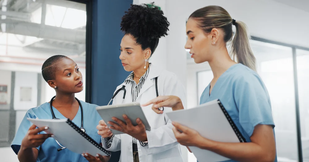 Travel nurses talking to a doctor while on shift.