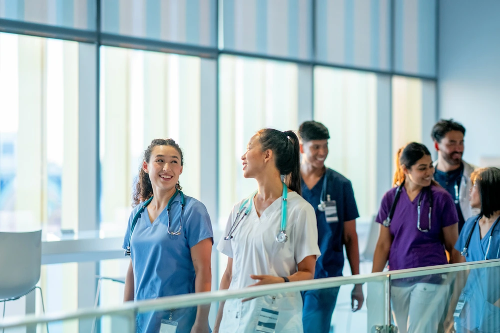 Hospital staff talking as they walk down the hallway.